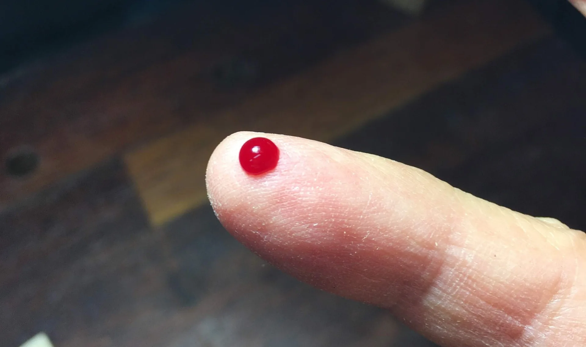 Drop of blood on finger representing builder DNA