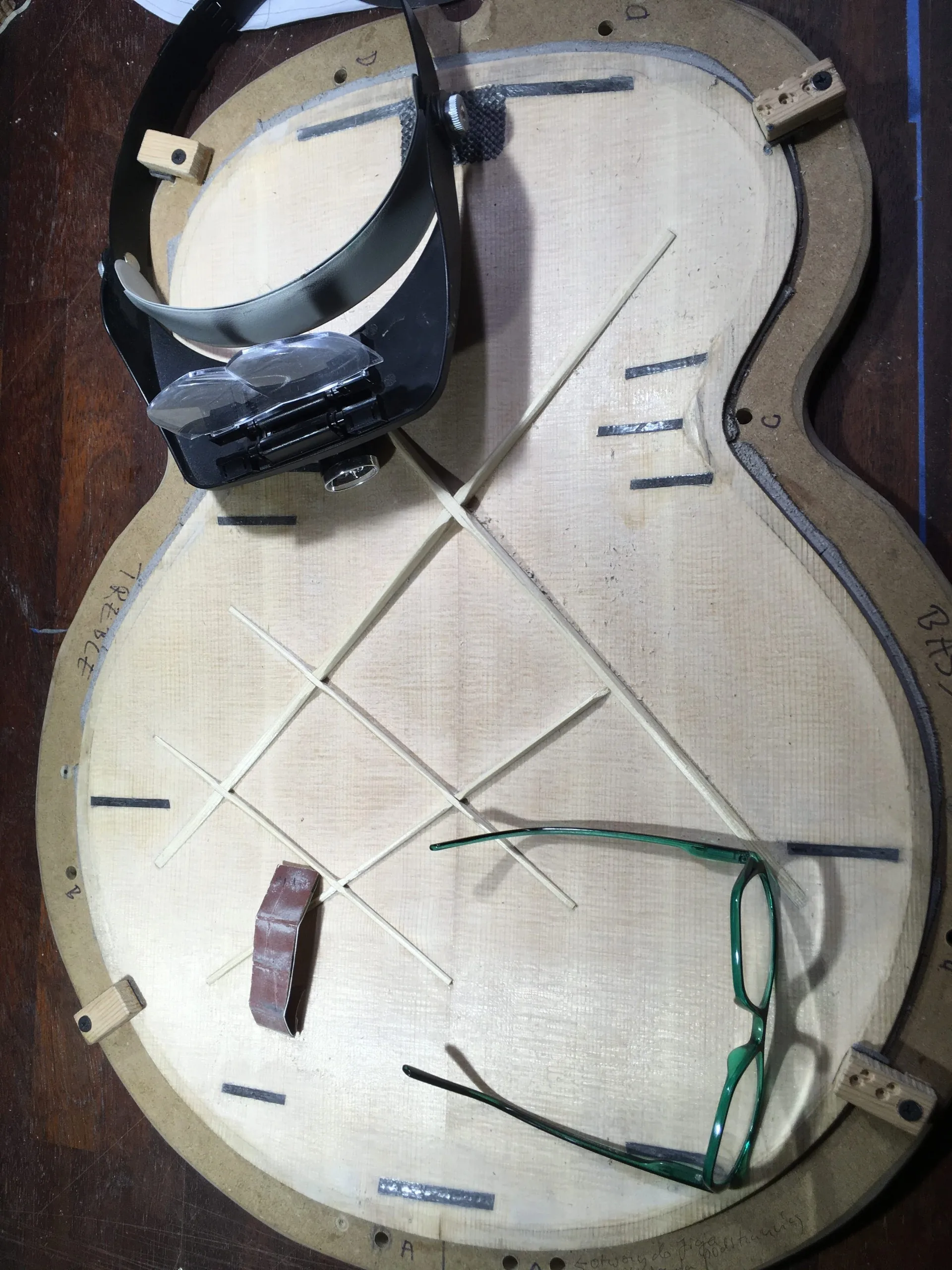 Inside structure of guitar top plate with tools in workshop