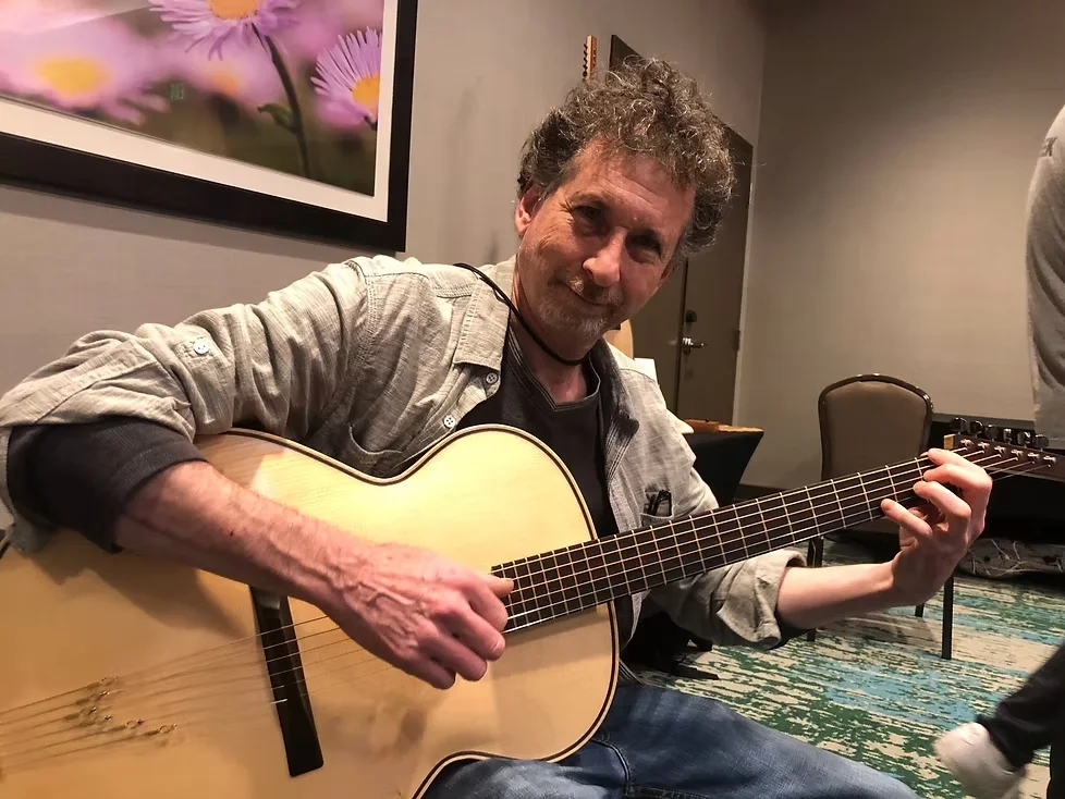 Bill Comins inspecting guitar